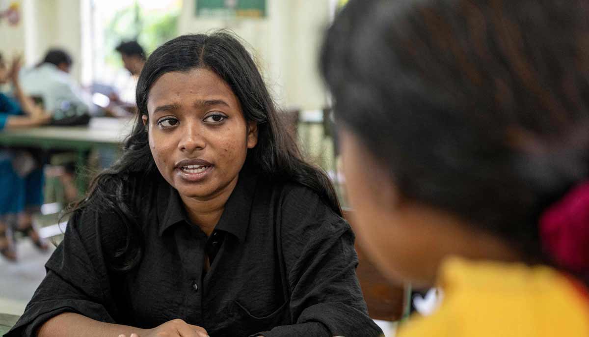 Adity Islam, a philosophy student at Dhaka University chatting with her friend inside the campus in Dhaka.— AFP