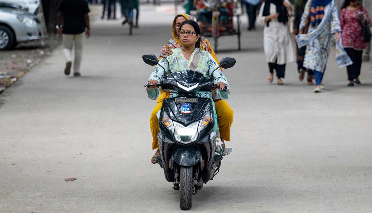 Woman riding a motorbike across the Dhaka University campus in Dhaka.— AFP