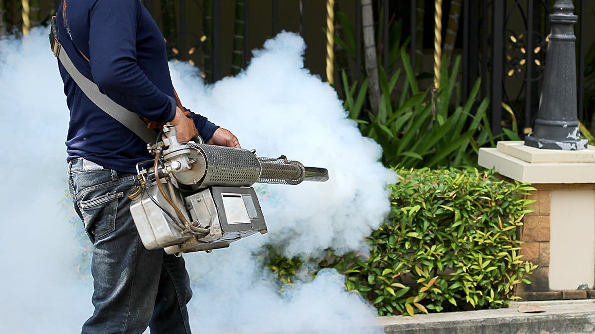 A man sprays property for mosquitos.