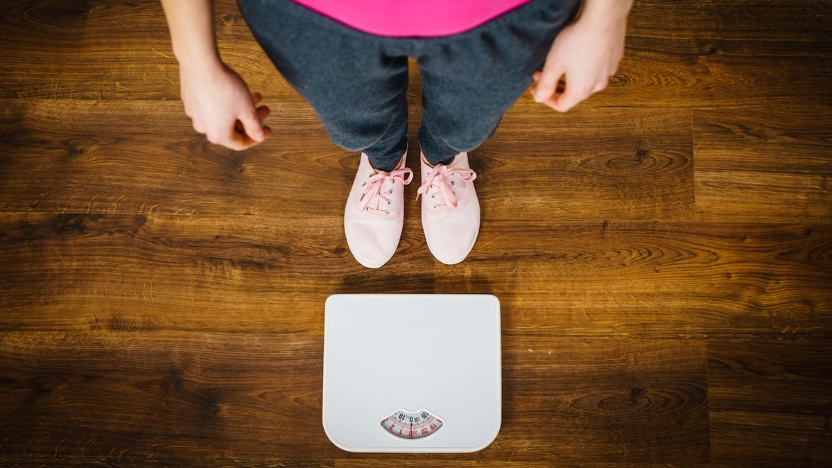 Girl looking down at scale