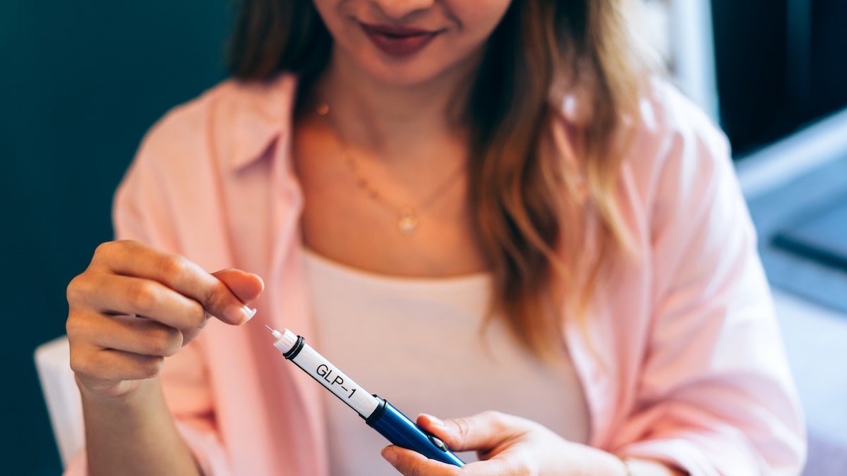 Woman holding GLP-1 medication