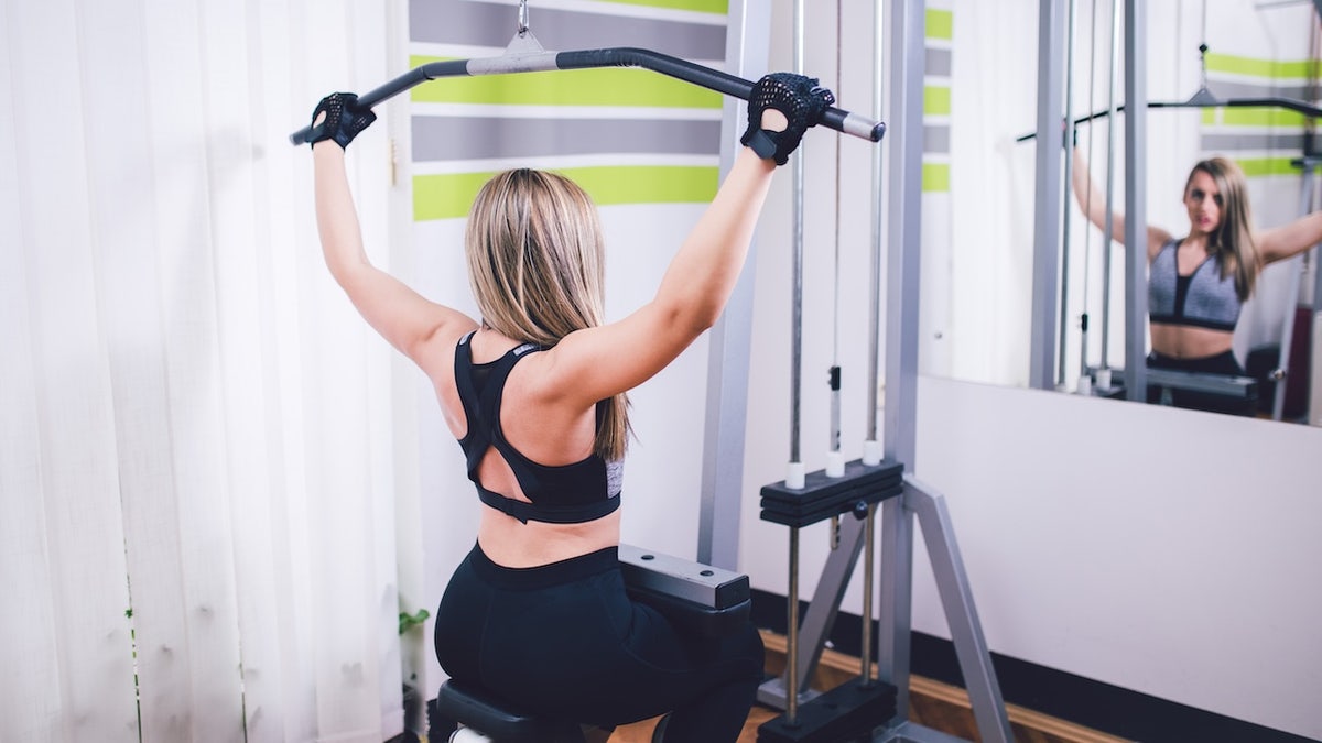 Woman using weight machine