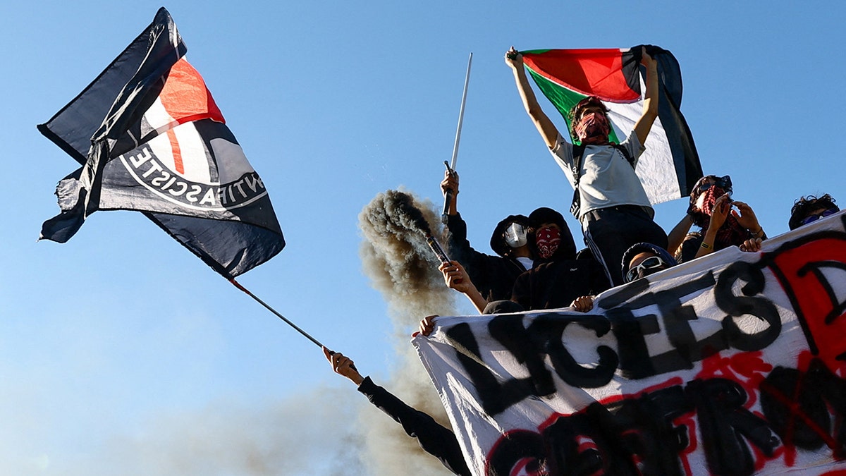 Protesters hold Palestinian and Antifa flags in France