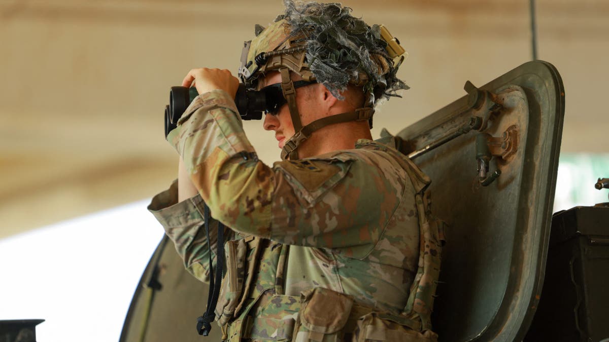 A U.S. Army soldier uses binoculars while riding a Stryker armored vehicle at the U.S.-Mexico border, as part of the Trump administration’s crackdown on immigration and following the establishment of a 260-mile military zone along the U.S. southern border in New Mexico and Texas, in El Paso, Texas, U.S., May 22, 2025. REUTERS/Jose Luis Gonzalez