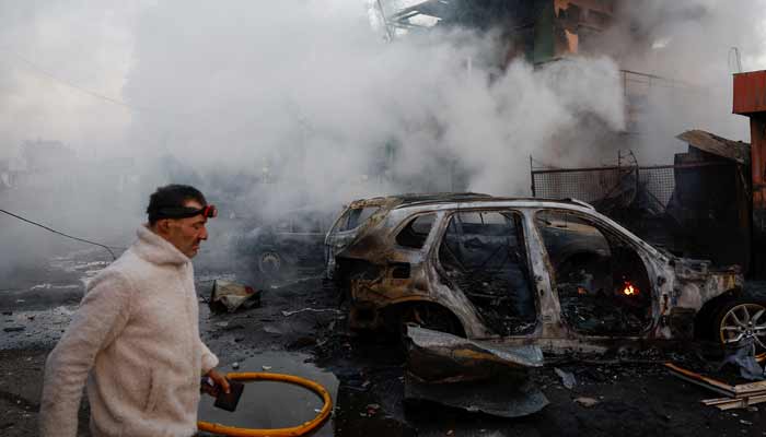 A resident walks at the site of private car garages hit by a Russian missile strike, amid Russias attack on Ukraine, in Kyiv, Ukraine October 7, 2026.— Reuters