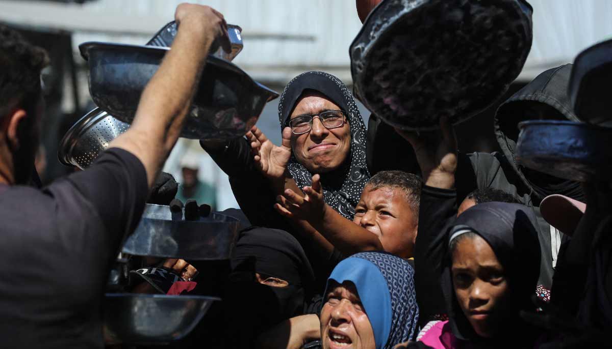Displaced Palestinians from Beit Hanoun, waiting to receive food at a charity kitchen in Khan Yunis, in the southern Gaza Strip. — AFP