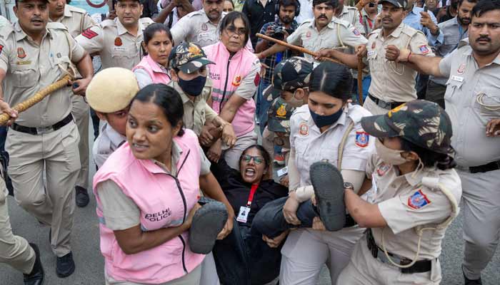 Security personnel and police detain a journalist during a protest by the Cockroach Janta Party (CJP) seeking the resignation of Indias Chief Election Commissioner Gyanesh Kumar, near the protest site in New Delhi, India, October 11, 2026. — Reuters