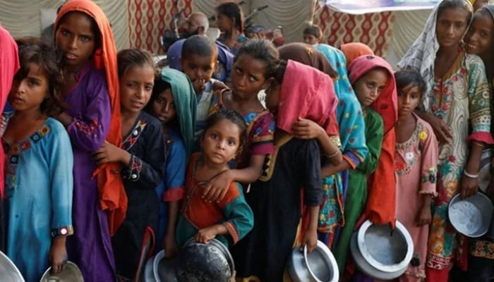 Flood victims gather to receive food handout in a camp following rains and floods during the monsoon season in Sehwan, Sindh, September 14, 2022. — Reuters