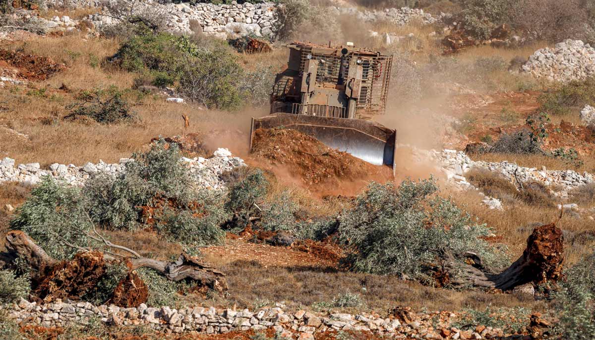 An Israeli military bulldozer uproots olive trees in a grove in the Palestinian village of Kafr Malik near Ramallah in the Israeli-occupied West Bank on October 14, 2026.— AFP