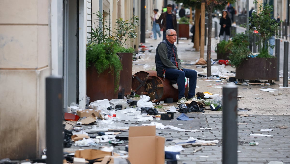 A man sits in the middle of the street next to trash left by rioters, the day after clashes during a national day of demonstrations against the cost of living and rising fuel prices, in Marseille, France, October 18, 2026. — Reuters