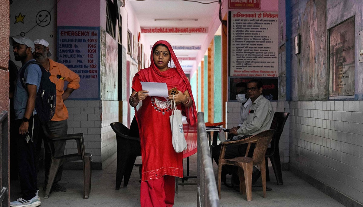 A woman leaves after submitting documents to register for the Draft Electoral Roll 2026 as part of the Election Commission of Indias Special Intensive Revision (SIR), at a voter verification camp in New Delhi on October 18, 2026. — AFP