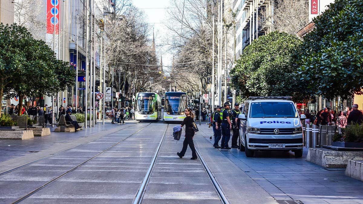 Victoria Police officers stand near a marked police van on Bourke Street Mall in Melbourne, Australia, on Aug. 29, 2026