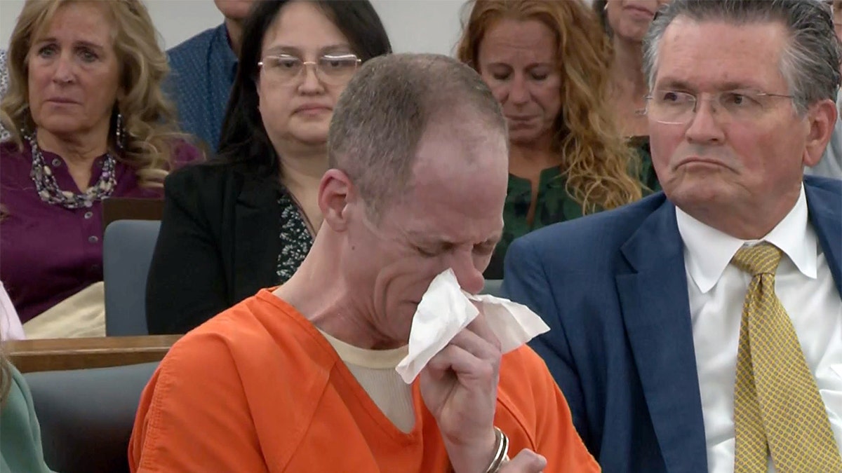 Caleb Flynn cries in court as a statement is read from one of his daughters before he was sentenced to life without the chance of parole, for killing his wife Ashley Flynn.