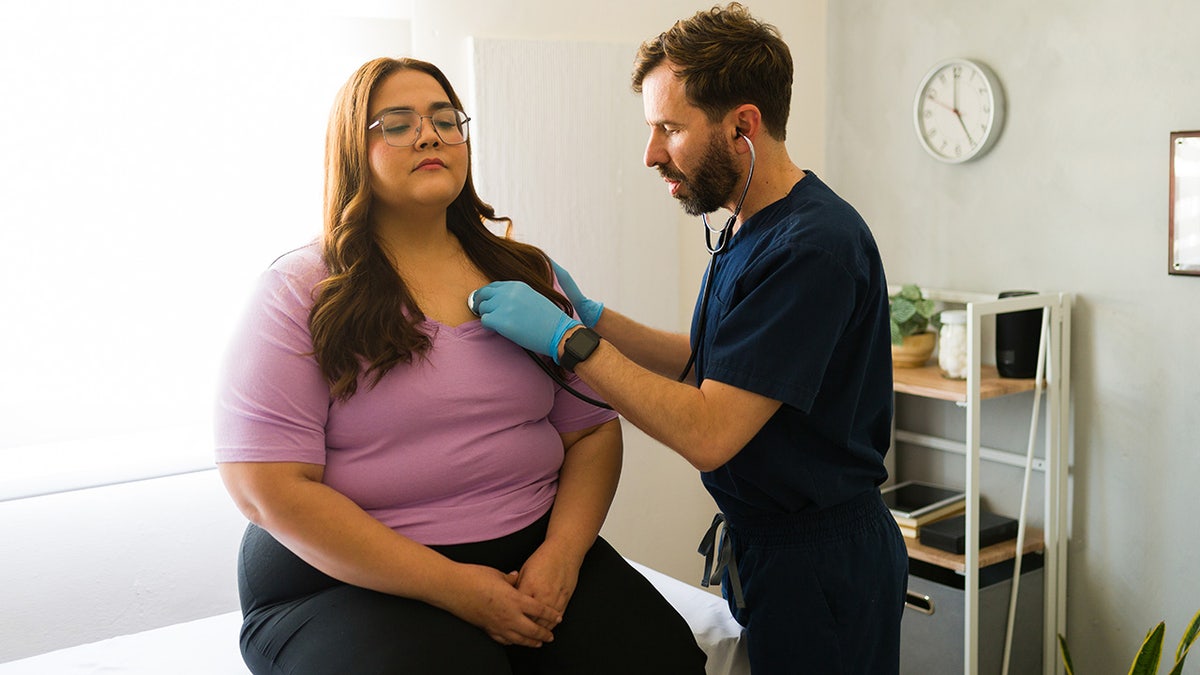 Young woman having heart checked by doctor.