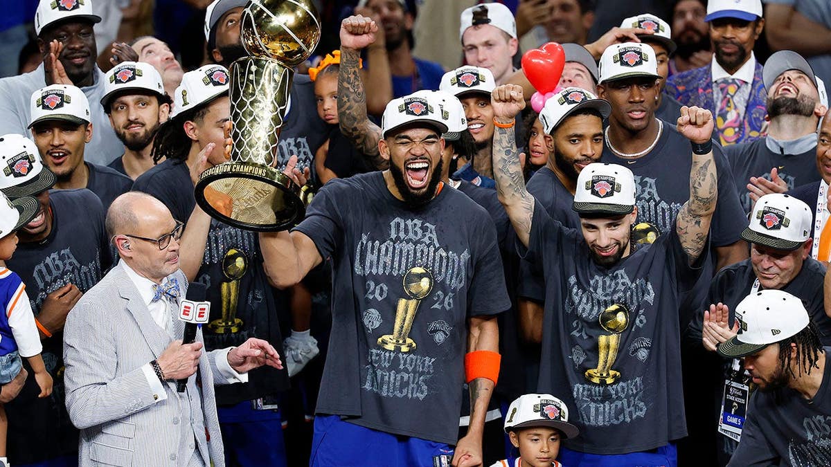 Karl-Anthony Towns celebrates with the Larry O'Brien Championship Trophy after winning the NBA Finals.