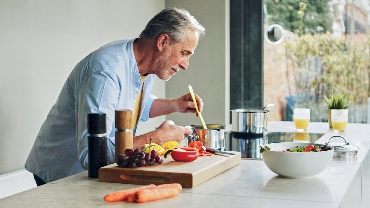Cooking, kitchen and senior man for lunch, supper and prepare healthy dinner in home. Retirement, food and mature person with natural ingredients, cutting vegetables and organic meal for nutrition