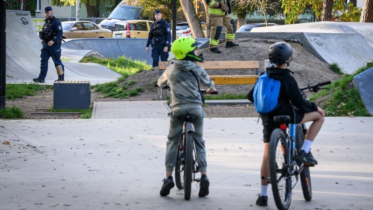 Children look at the scene of a knife attack