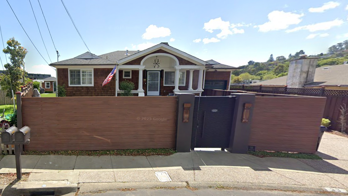 A house with an American flag outside and wooden fence