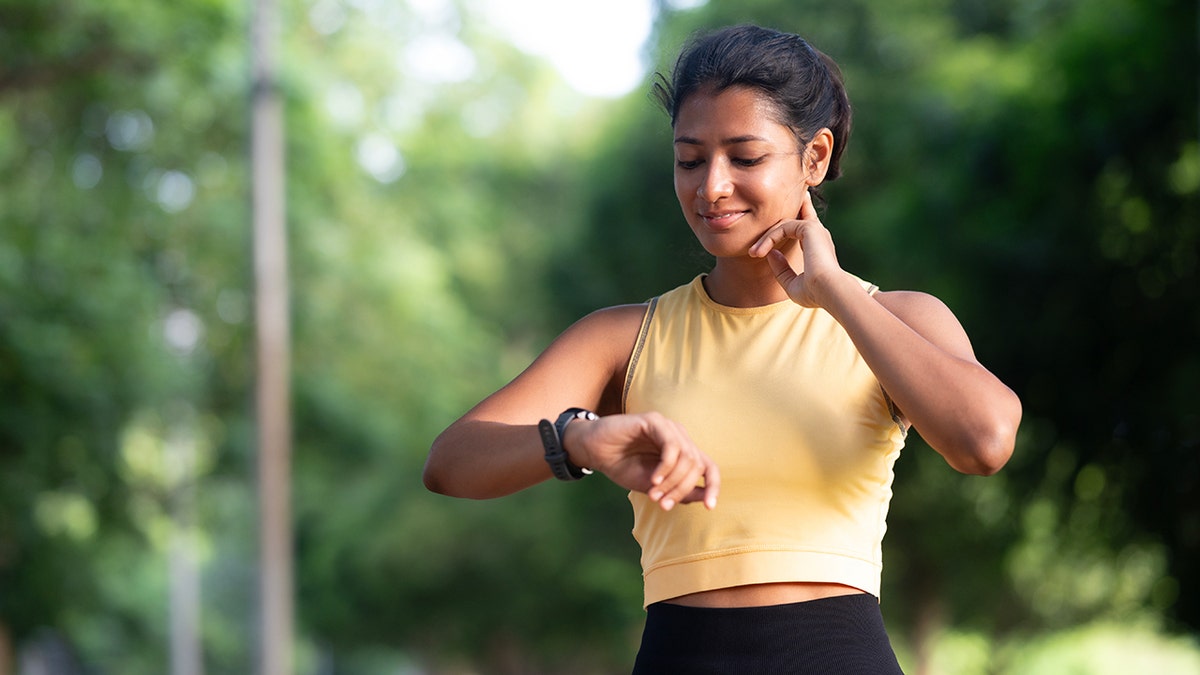 woman on a run checks pulse